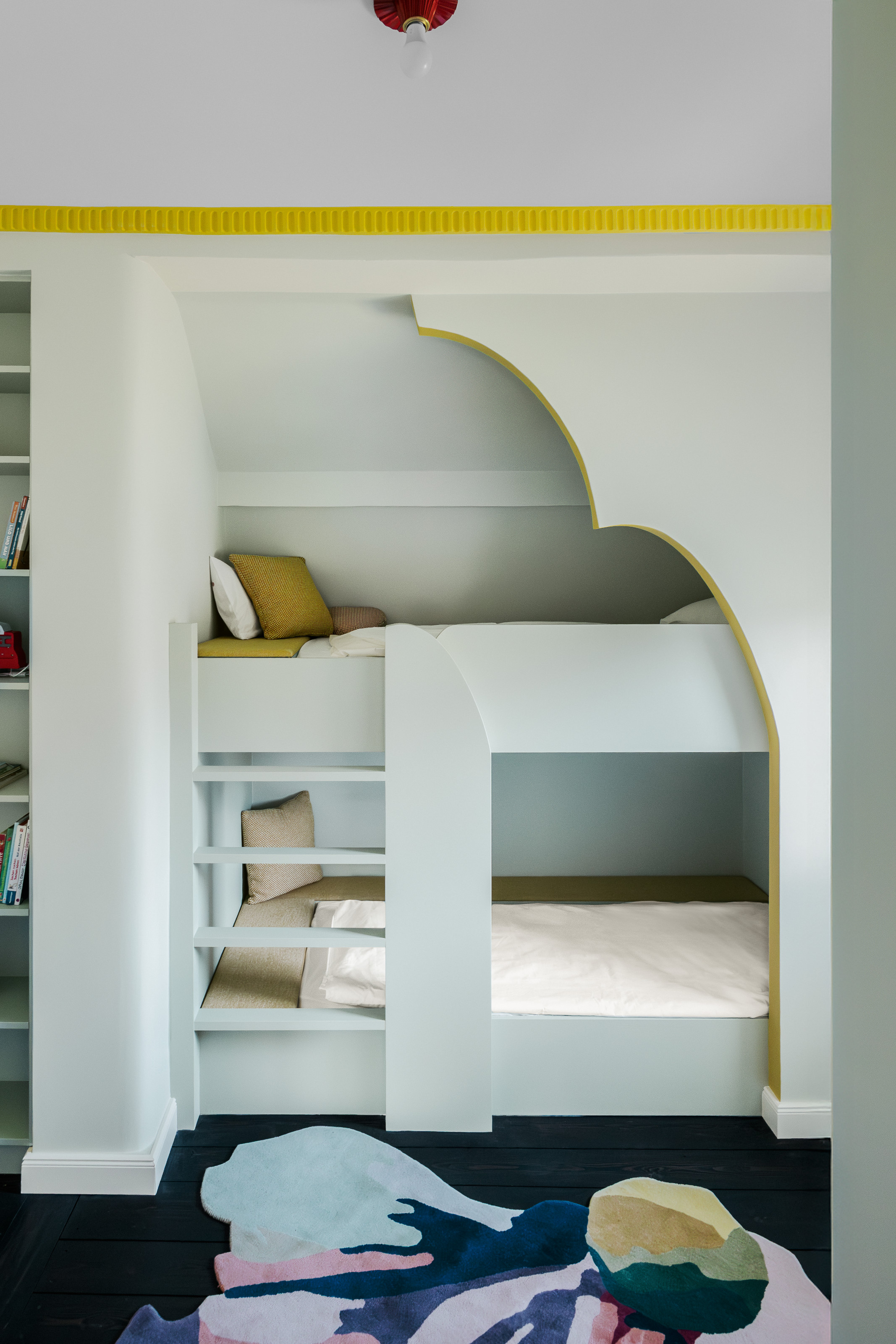 Kids' room with pale mint bunk beds built into wall behind curved cut-out