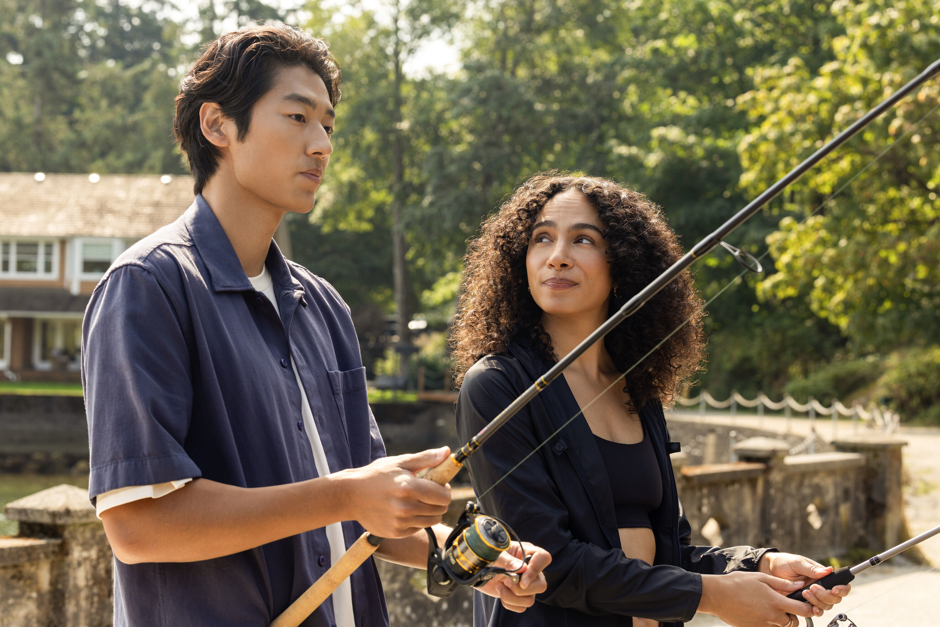 Joseph Chiu as Jordie and Aurora Perrineau as Chantal fishing on a dock on a sunny day in 'Every Year After.'