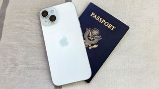 An iPhone 15 sitting on top of a U.S. passport