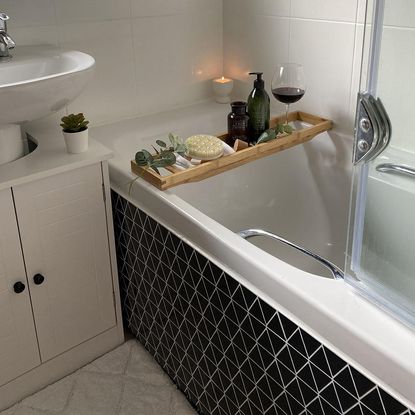 White bathroom with black tiled bathtub