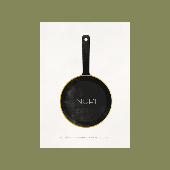 A book with a white cover features a cast-iron pan on its front with a yellow rim and the inscription &quot;NOPI&quot; in its centre, and sits against a dark green background.
