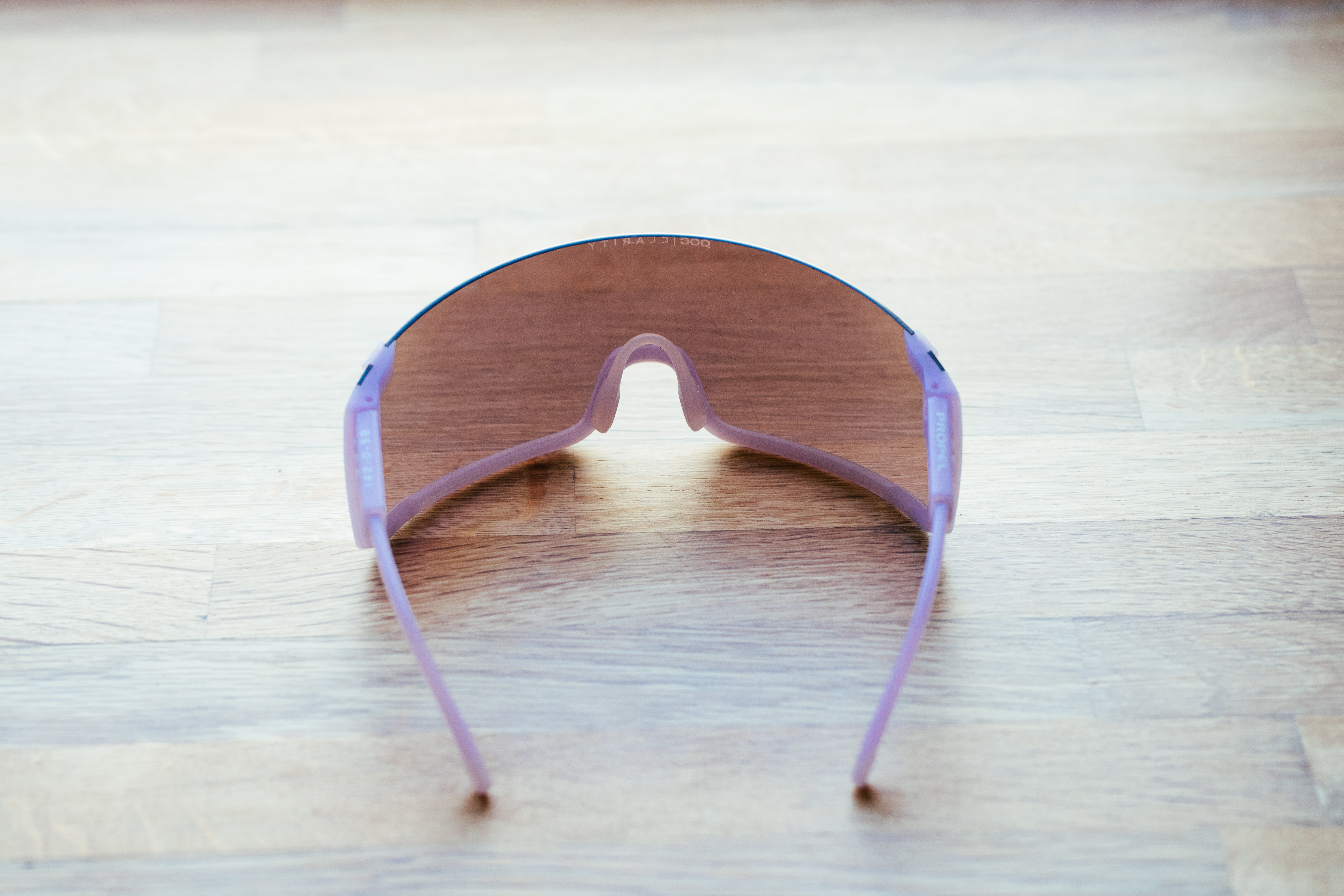 A space-age looking pair of wraparound cycling glasses on a wooden surface