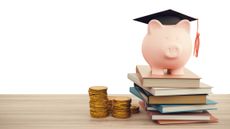 High university living costs with piggy bank graduation cap and books