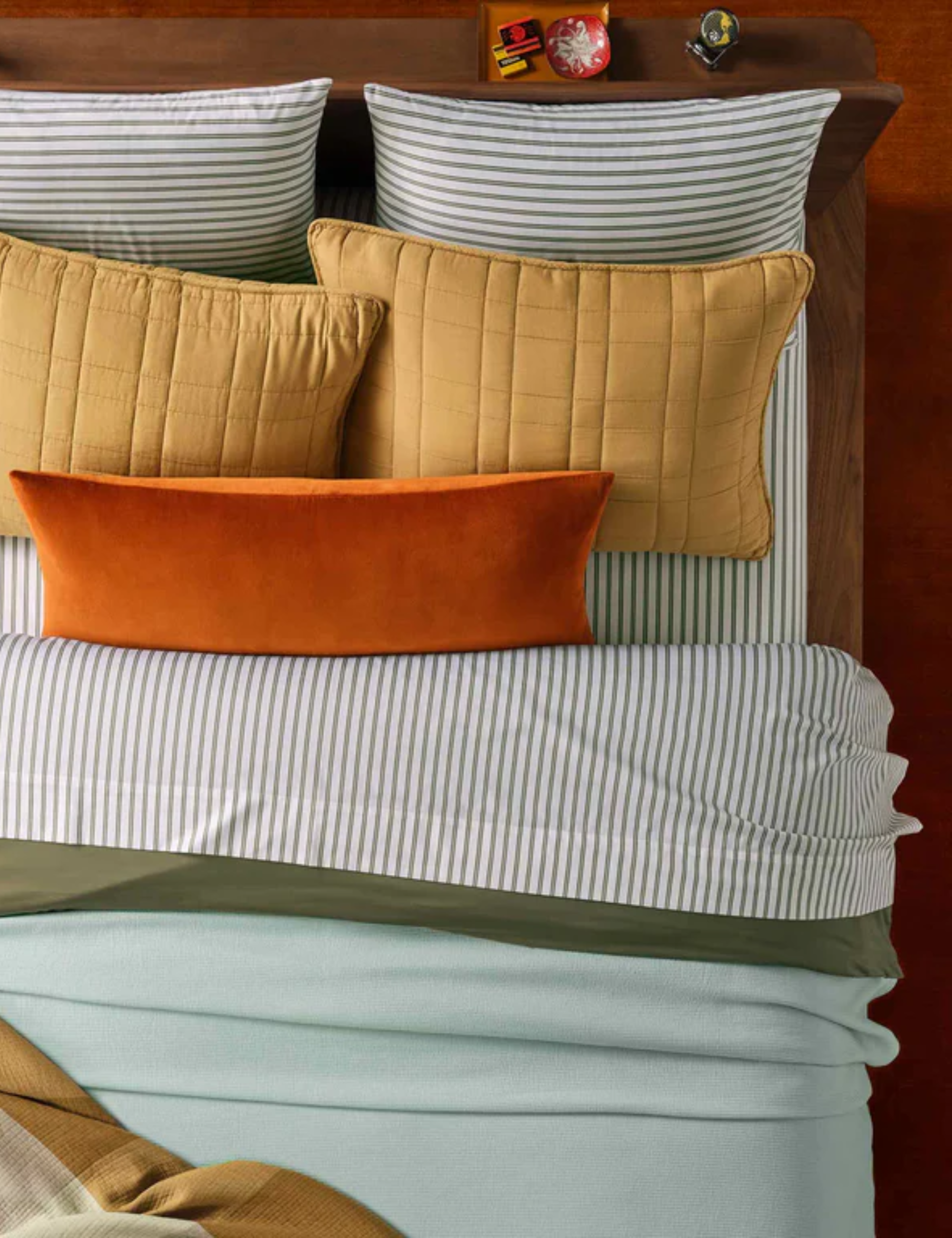 Wood-paneled bedroom featuring colorful striped and quilted bedding