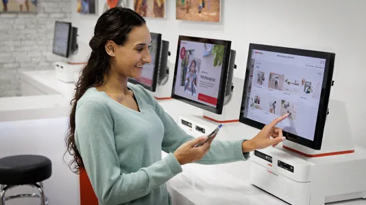 Woman using a Kodak Moments print kiosk