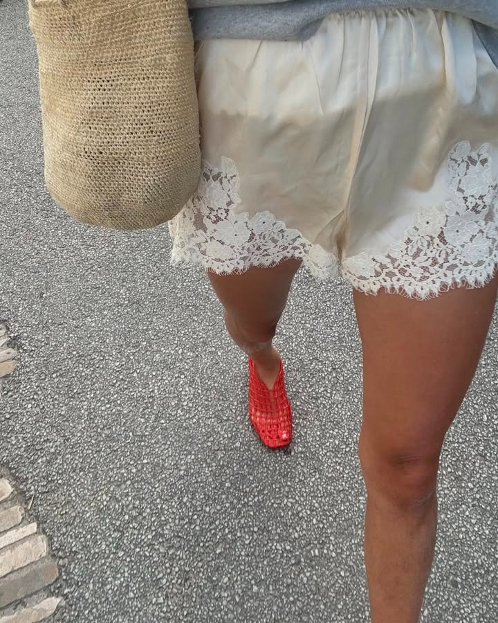 Woman in satin lace trimmed shorts and red jellies