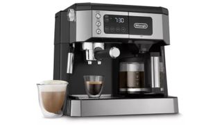 The De'Longhi all in one coffee maker on a white background with coffee at the side and an espresso underneath
