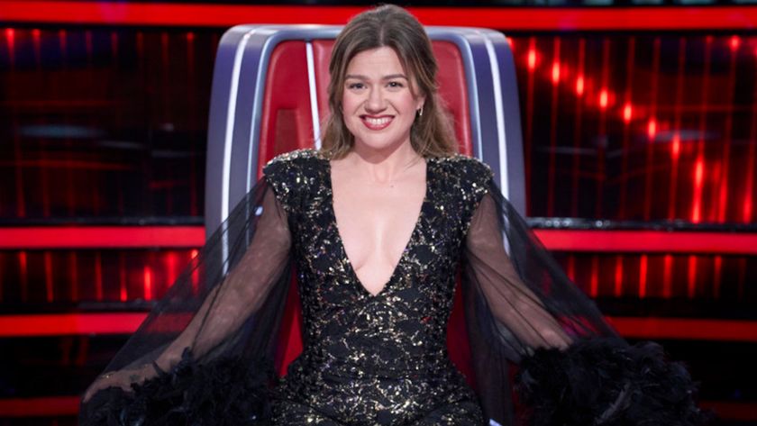 Kelly Clarkson sits in a Big Red Chair at The Voice Season 27 finale, where she performed.