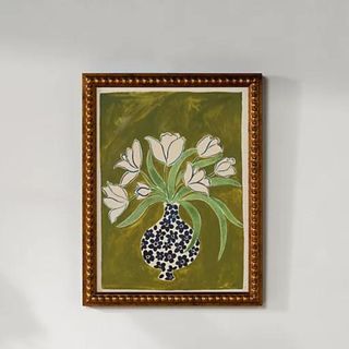 A gold framed painting of a vase of flowers against a green background