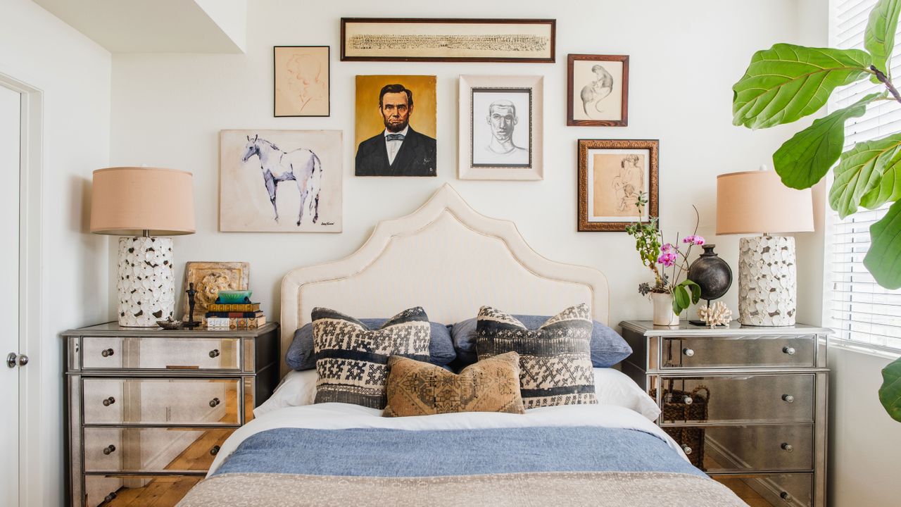 Box room ideas illustrated by a white gallery wall above a white bed with blue cushions.