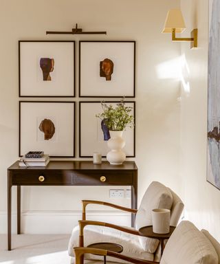 traditional living room with warm white walls and dark wooden dresser with gallery wall