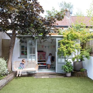 Garden with summer house play room, garden bench, lawn, Japanese maple tree