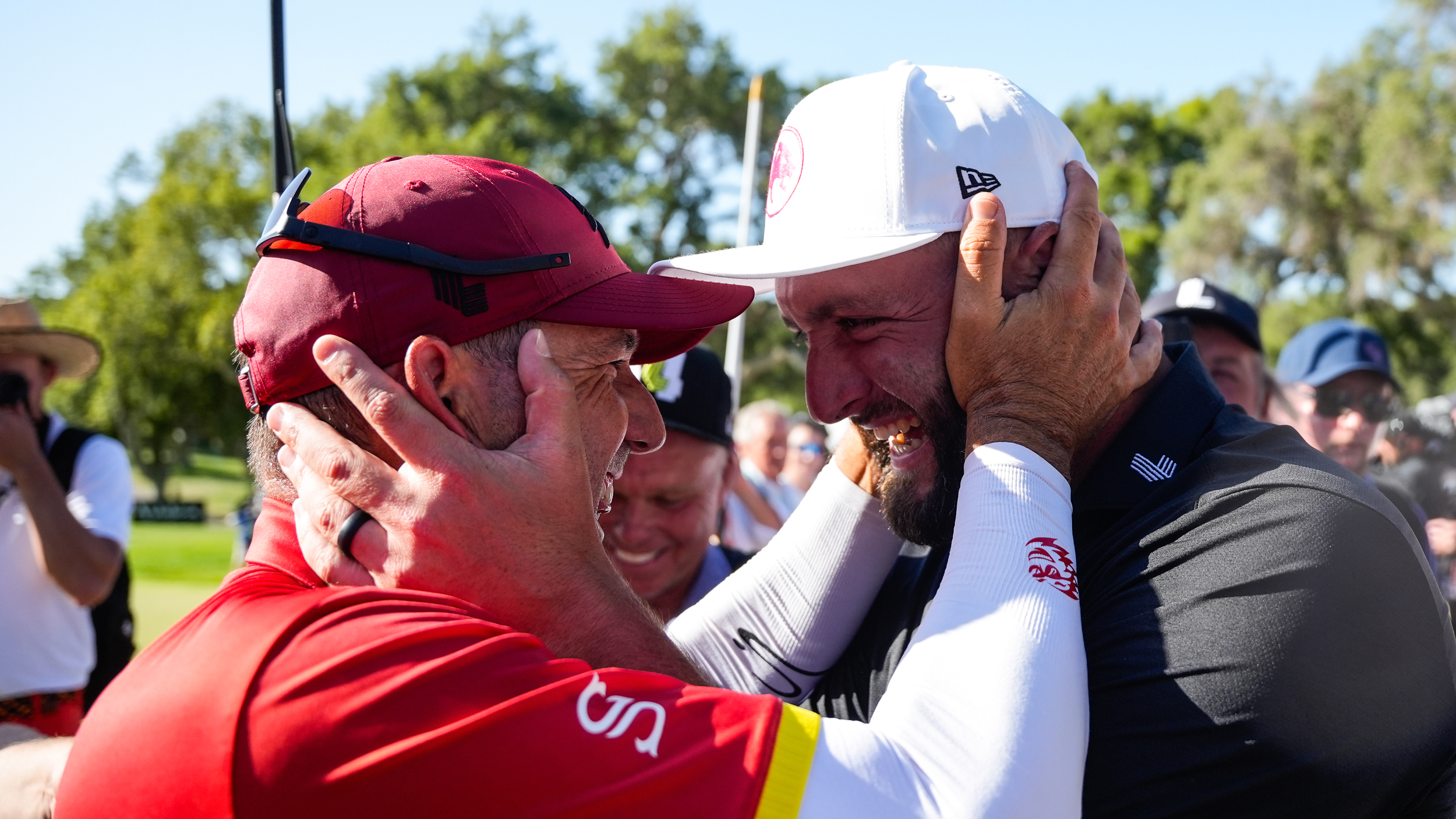 Jon Rahm (right) and Sergio Garcia smile while holding each other&#039;s faces after the final hole of LIV Golf Andalucia 2025