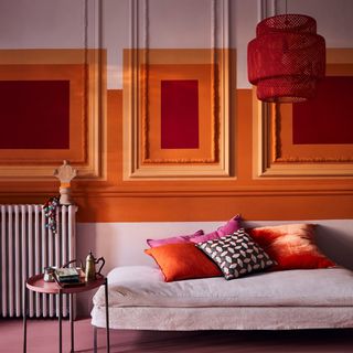 A creative painted living room wall in orange and red squares of colour