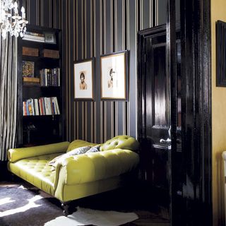 green sofa with brown book shelf with laminated wall