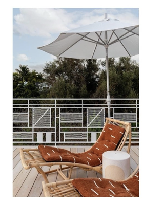 White painted metal deck railing with light wood decking and orange sun chair