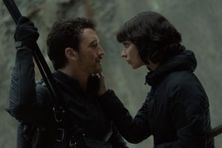 miles teller and anya taylor joy lean into one another while suspended on a cliff in the movie the gorge