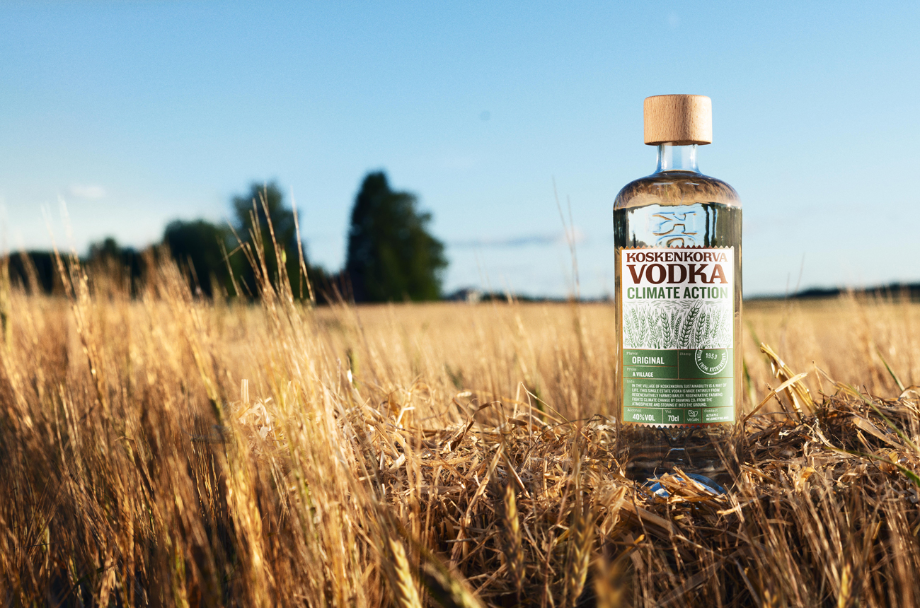 A bottle of vodka in a wheat field with a blue sky