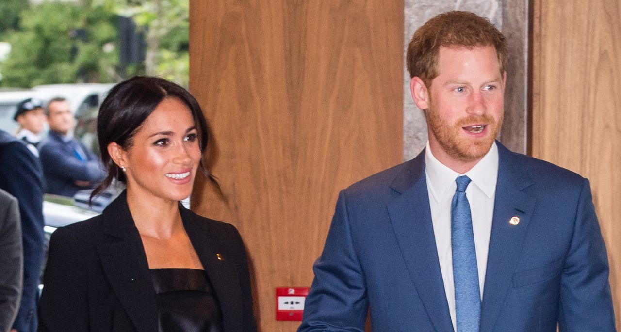 Meghan Markle and Prince Harry walking into an event wearing blazers