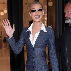 Bella wears a pinstripe dress with a white polo shirt and white slingback kitten heels.