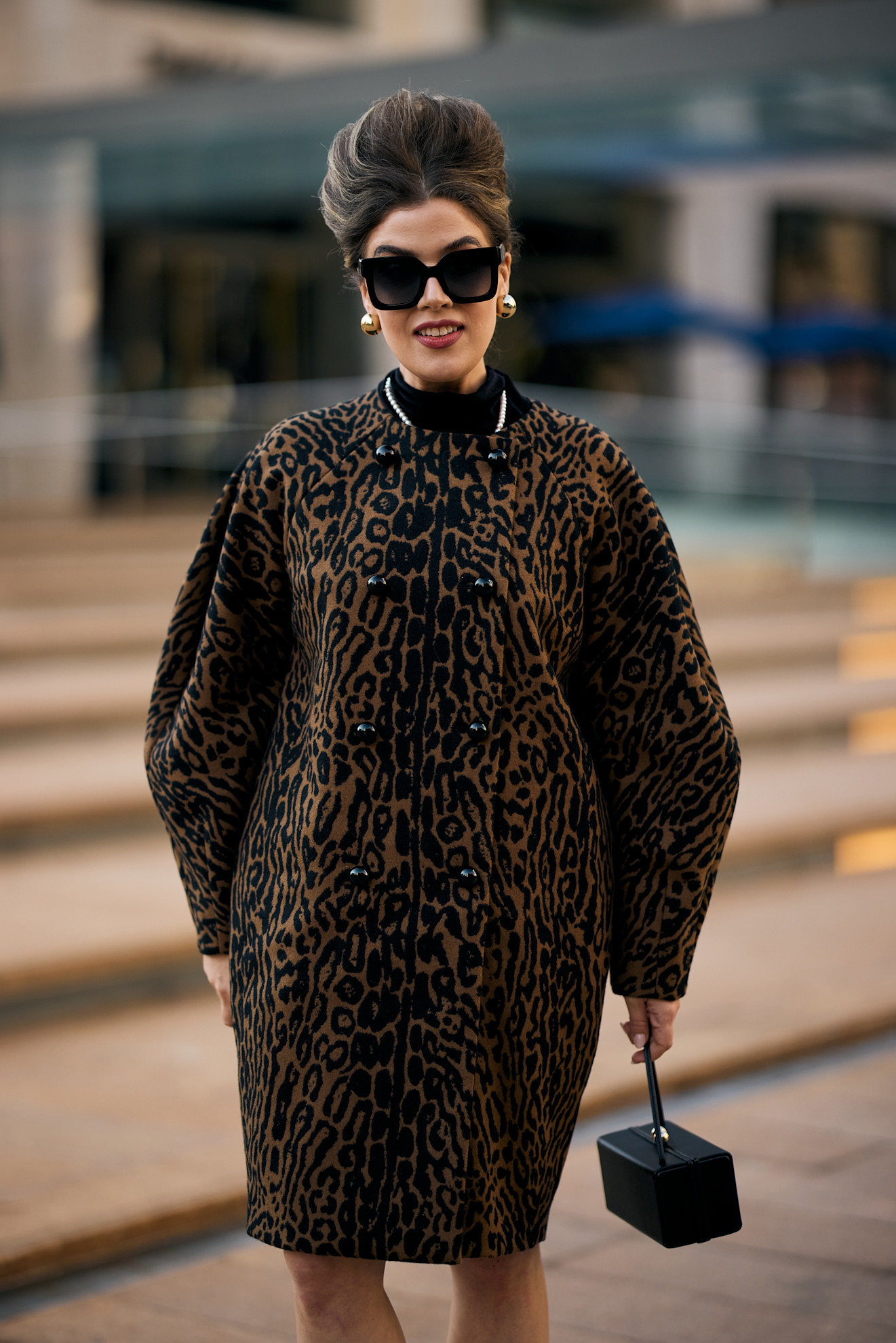a woman in a leopard coat with dark sunglasses