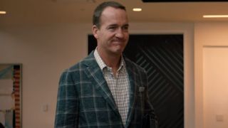 Peyton Manning stands in an office with a look of upset in You're Cordially Invited.