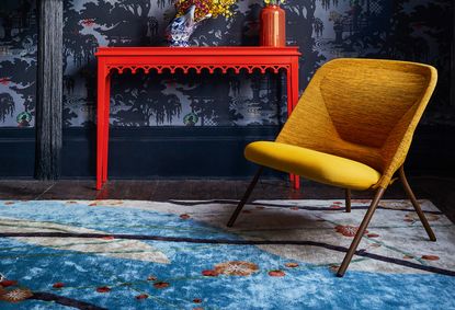 yellow chair, blue rug and red table in a living room decorated with primary colors