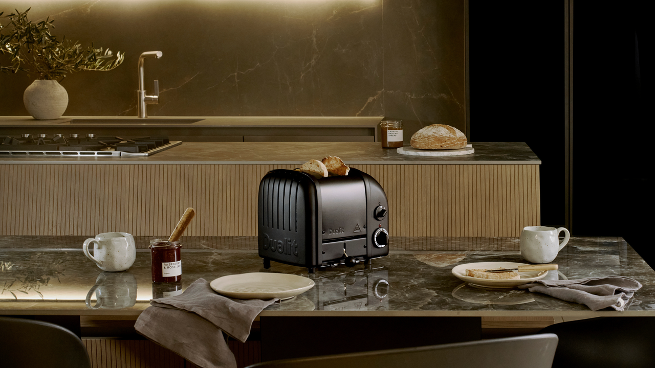 Stealth edition black toaster on a black marble kitchen countertop.