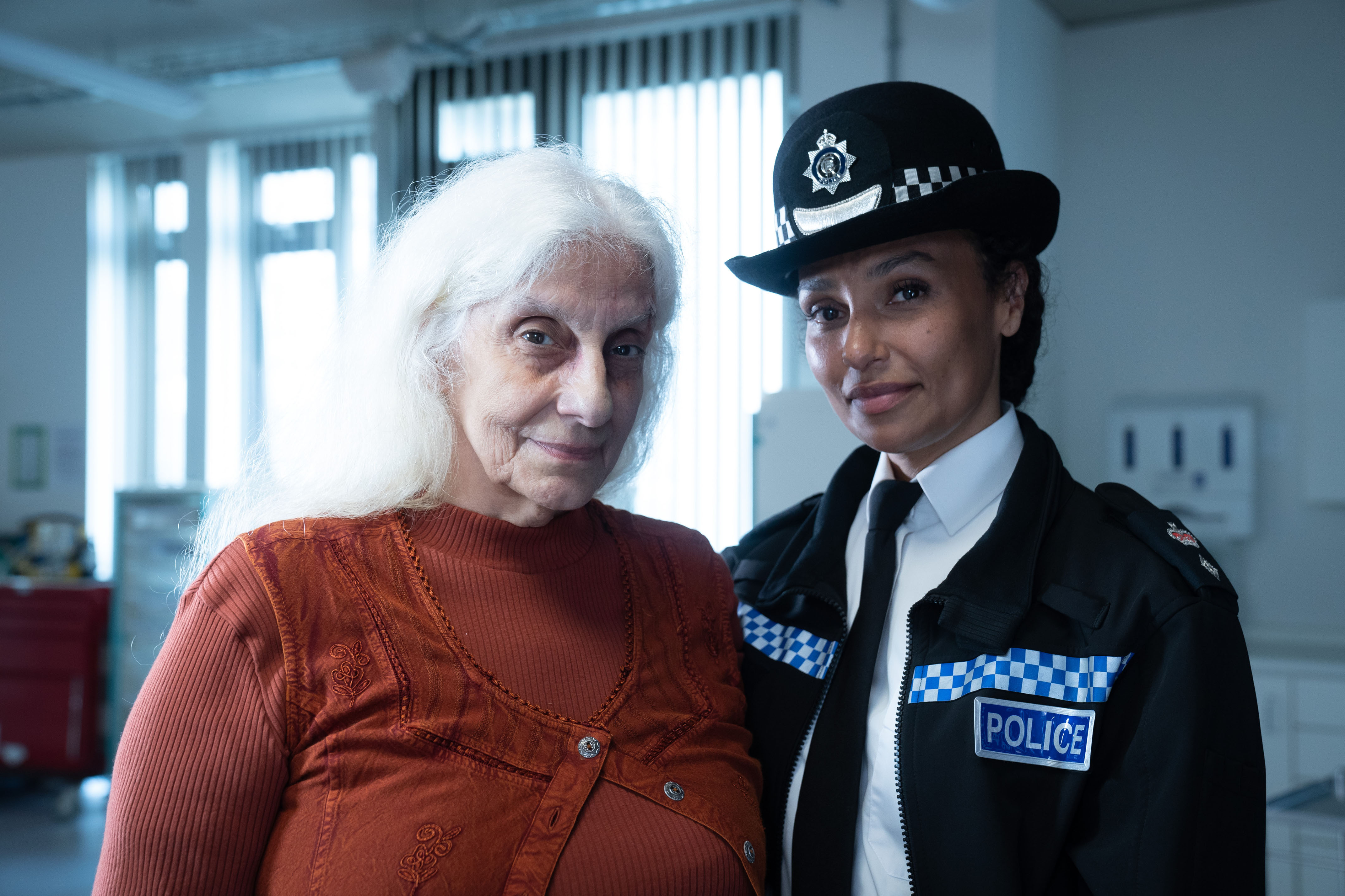 Ella (Souad Faress) stands with her granddaughter, Chief Superintendent Charlie Woods (Jade Harrison) in the hospital ward. Both are smiling faintly into the camera.