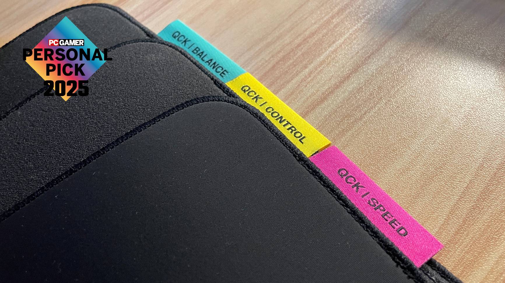 Three Steelseries QcK Performance mouse pads on a desk with a PC Gamer Personal Pick 2025 label on top