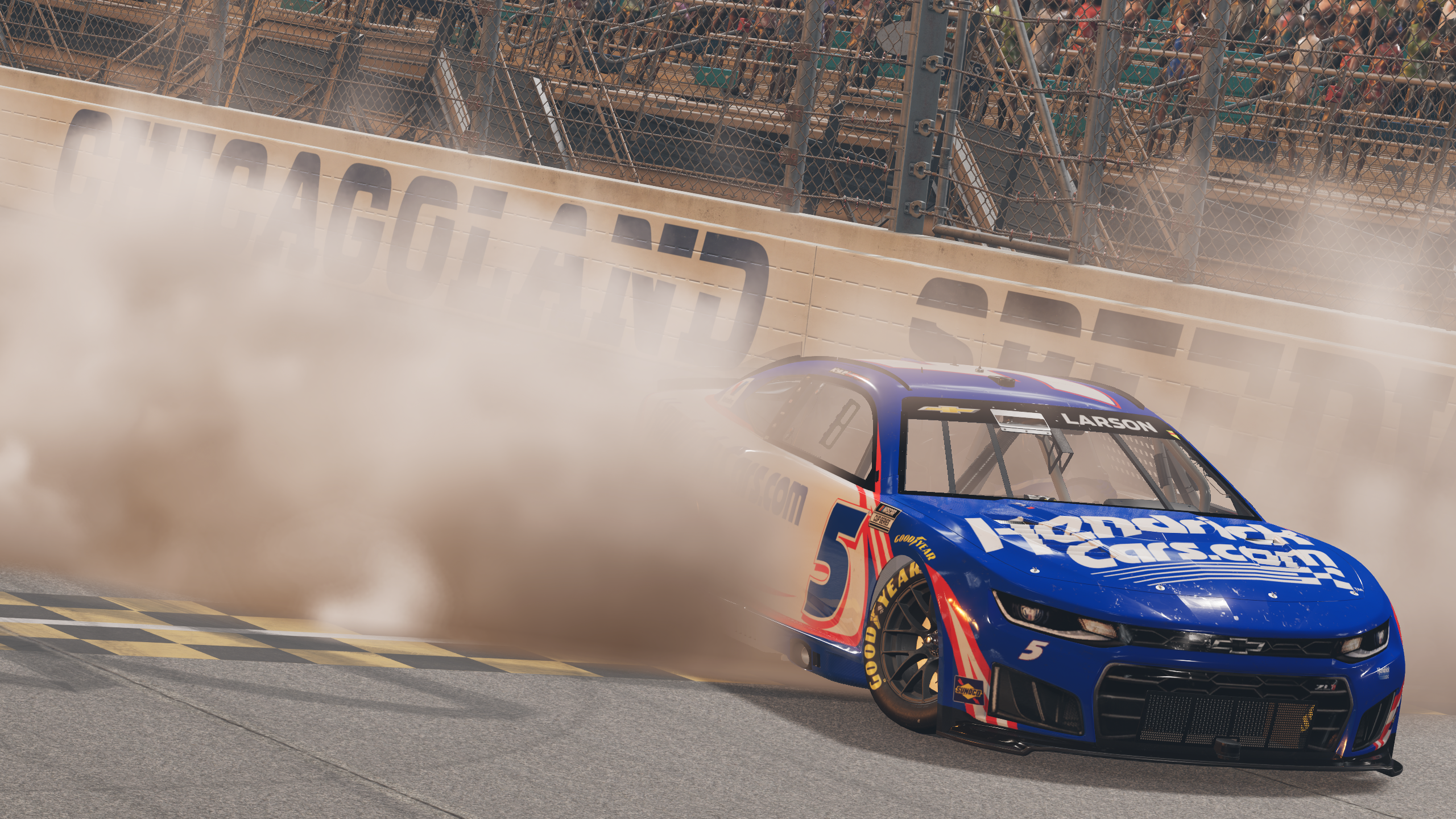 A promotional screenshot for NASCAR 26 showing Kyle Larson's number 5 Hendrick Motorsports Chevrolet doing a burnout at Chicagoland Speedway. 