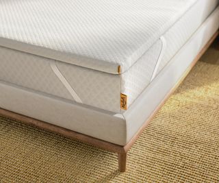 Nolah mattress topper on a mattress and wooden bed frame