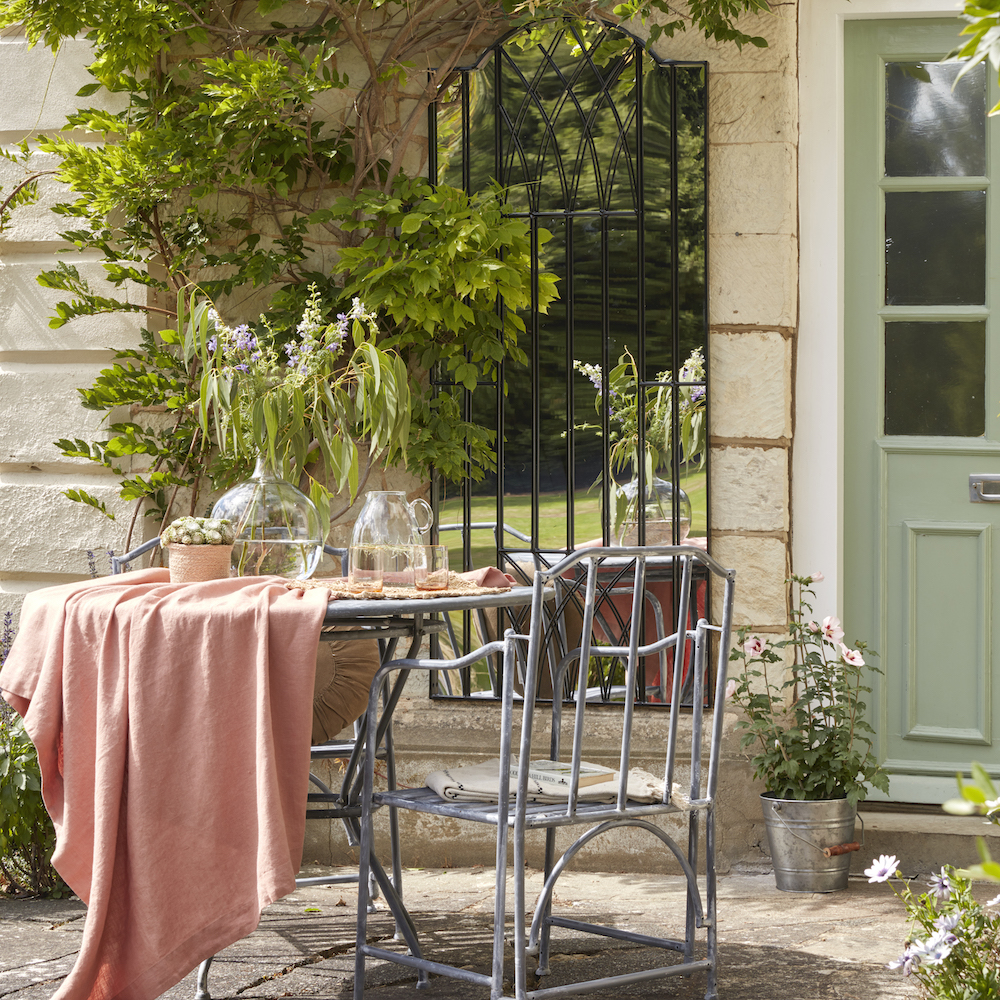 metal bistro set and garden mirror in patio area