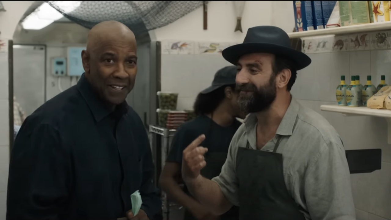 Daniel Peroni sorride mentre indica il cappello che Denzel Washington gli ha regalato in The Equalizer 3.