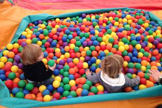 Two young boys playing in a ball pit