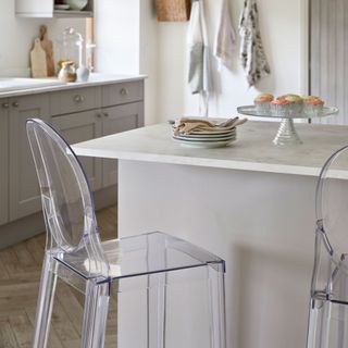 Clear breakfast bar stools in an open-plan Shaker-style kitchen