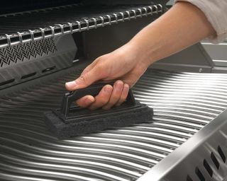 Using a grill sponge to wipe down grill grates