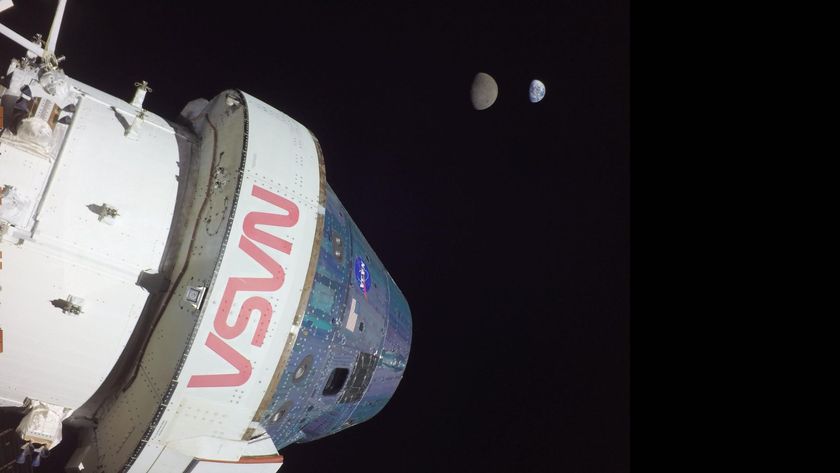 A large white space shuttle labeled in red &quot;NASA&quot; is seen in the darkness of space. 