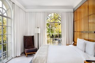 An elegant hotel room in Mexico City, all white linens and sun light streaming in