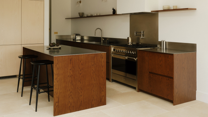 bright and light kitchen with dark timber cabinetry and stainless steel counters