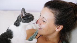 Cat licking lady's nose
