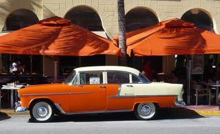 Orange and cream vehicle in front of orange sun umbrellas