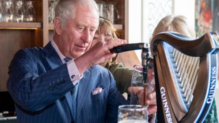 Prince Charles, Prince of Wales pours a pint of Guinness during a visit to The Irish Cultural Centre on March 15, 2022 in London, England. The Prince of Wales and The Duchess of Cornwall visited the Irish Cultural Centre to celebrate the Centres 25th anniversary in the run-up to St Patricks Day.