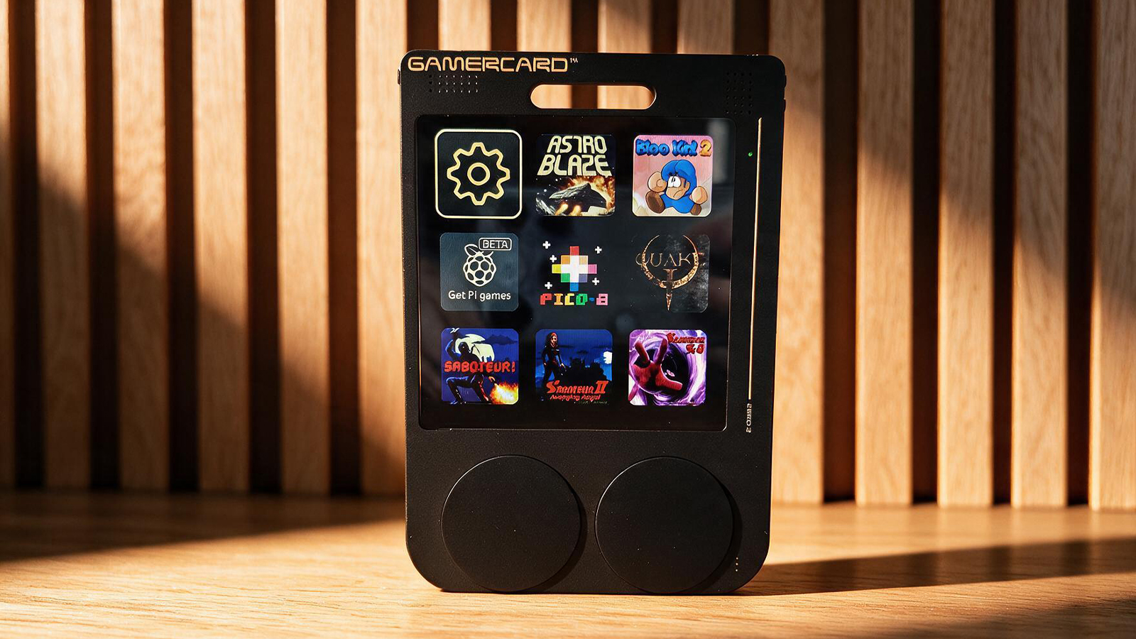 A small black gaming handheld in a wooden table