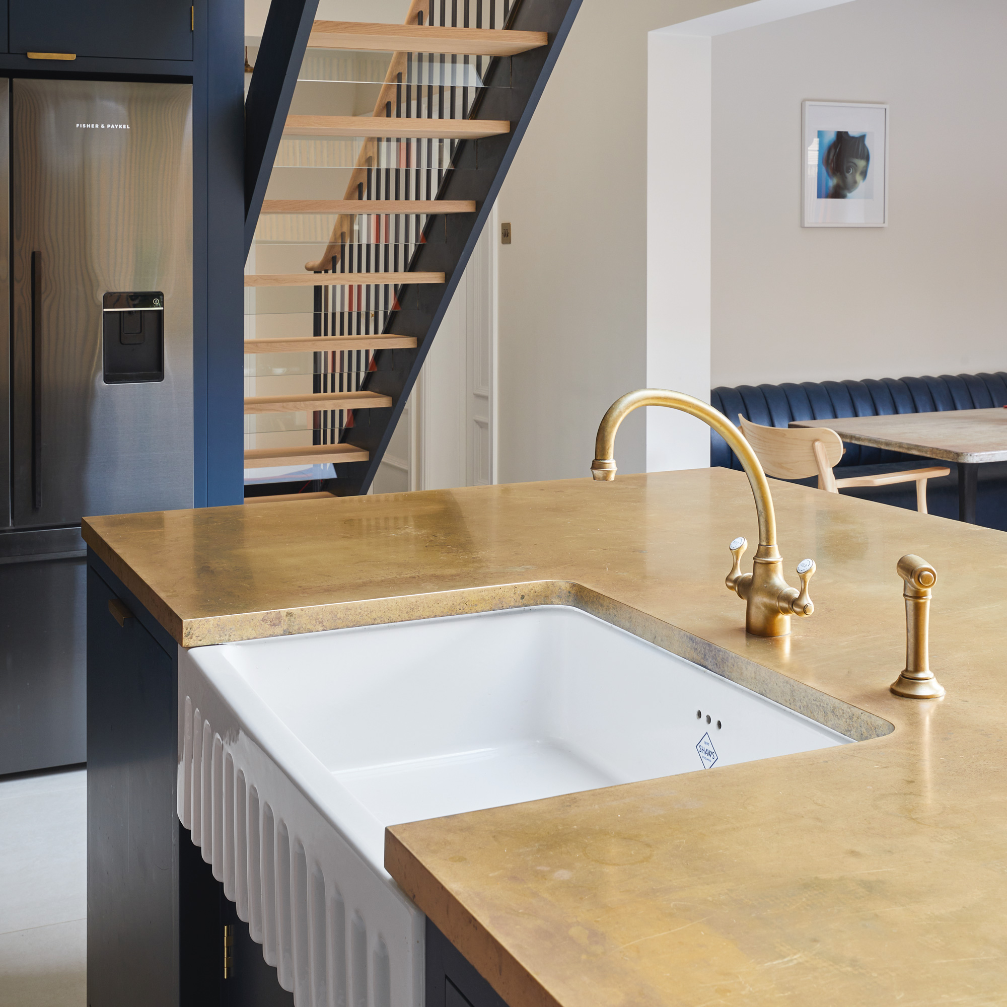 a Belfast sink with brass kitchen tap on a kitchen island