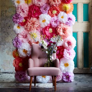 pink pom pom flower wall and pink chair with flower vase