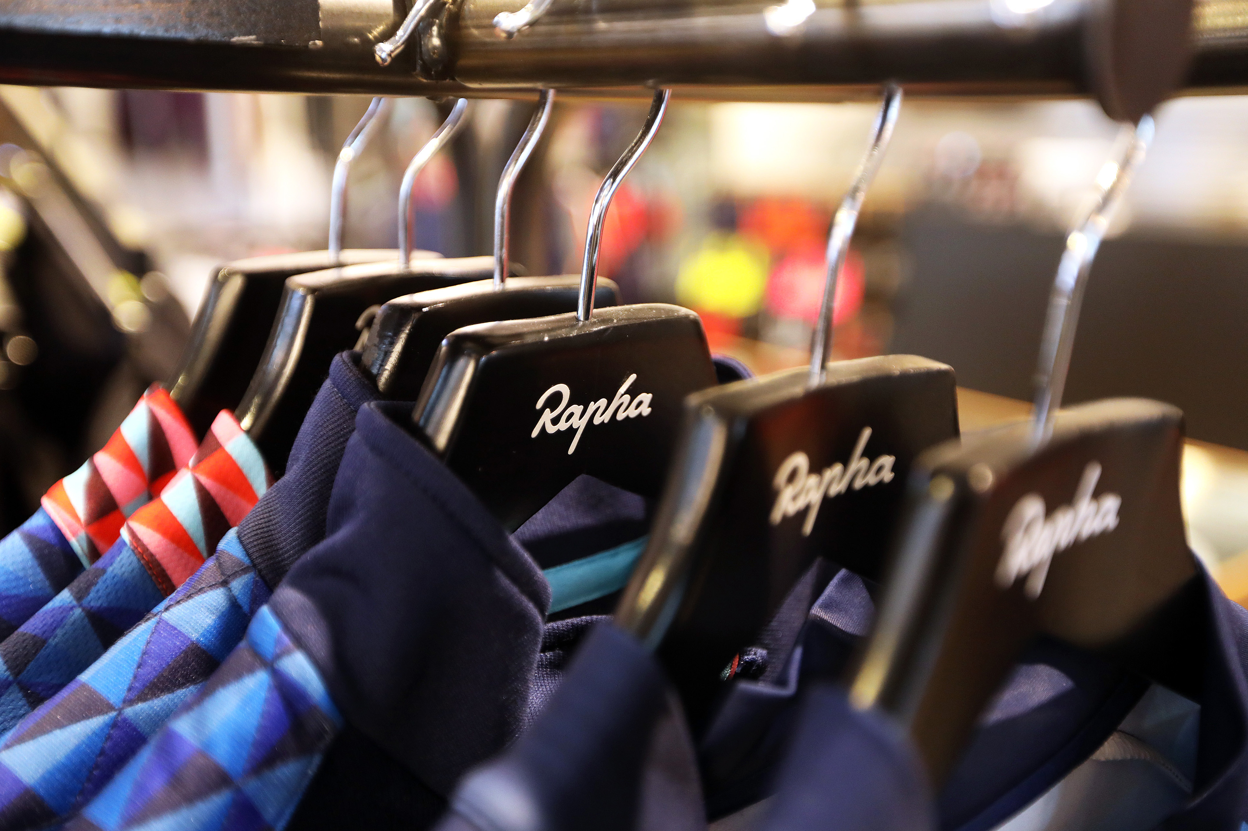 Rapha jerseys hanging on a rail