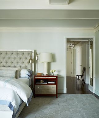 bedroom with cream walls and upholstered headboard