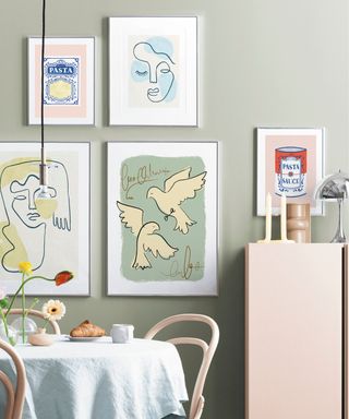 A dining room with pastel pink furniture and colorful wall art