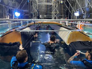 A group of people filming inside a submerged airplane